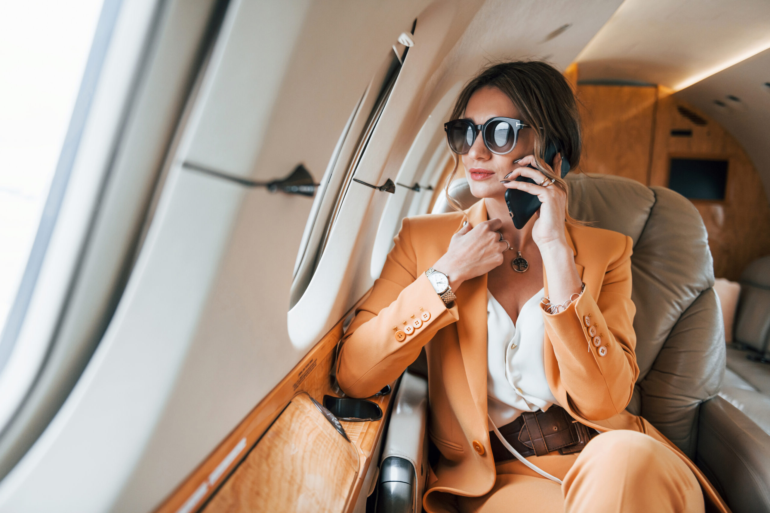 Young professional looking passenger on her phone on a plane