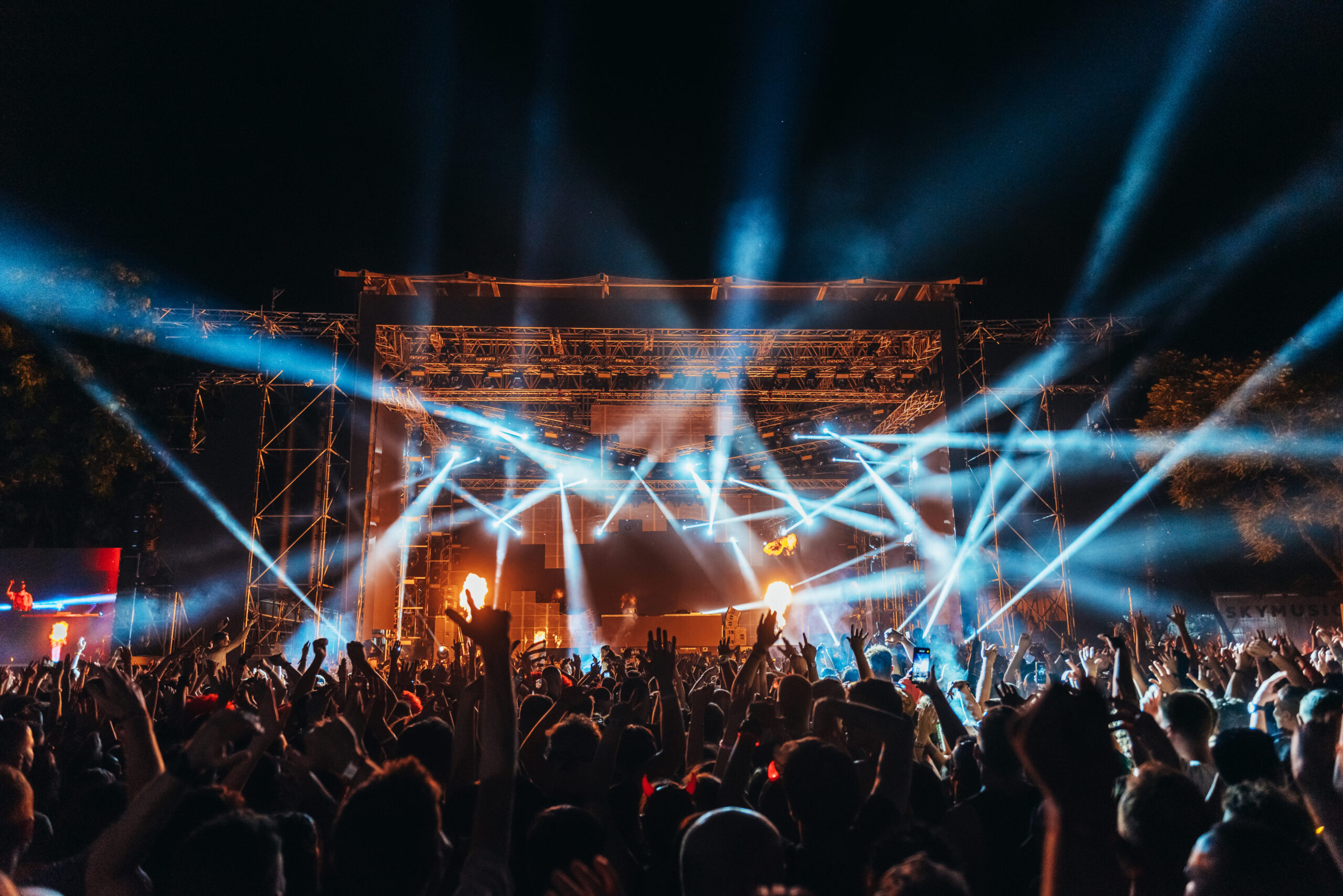 Silhouettes of concert crowd in front of bright stage lights