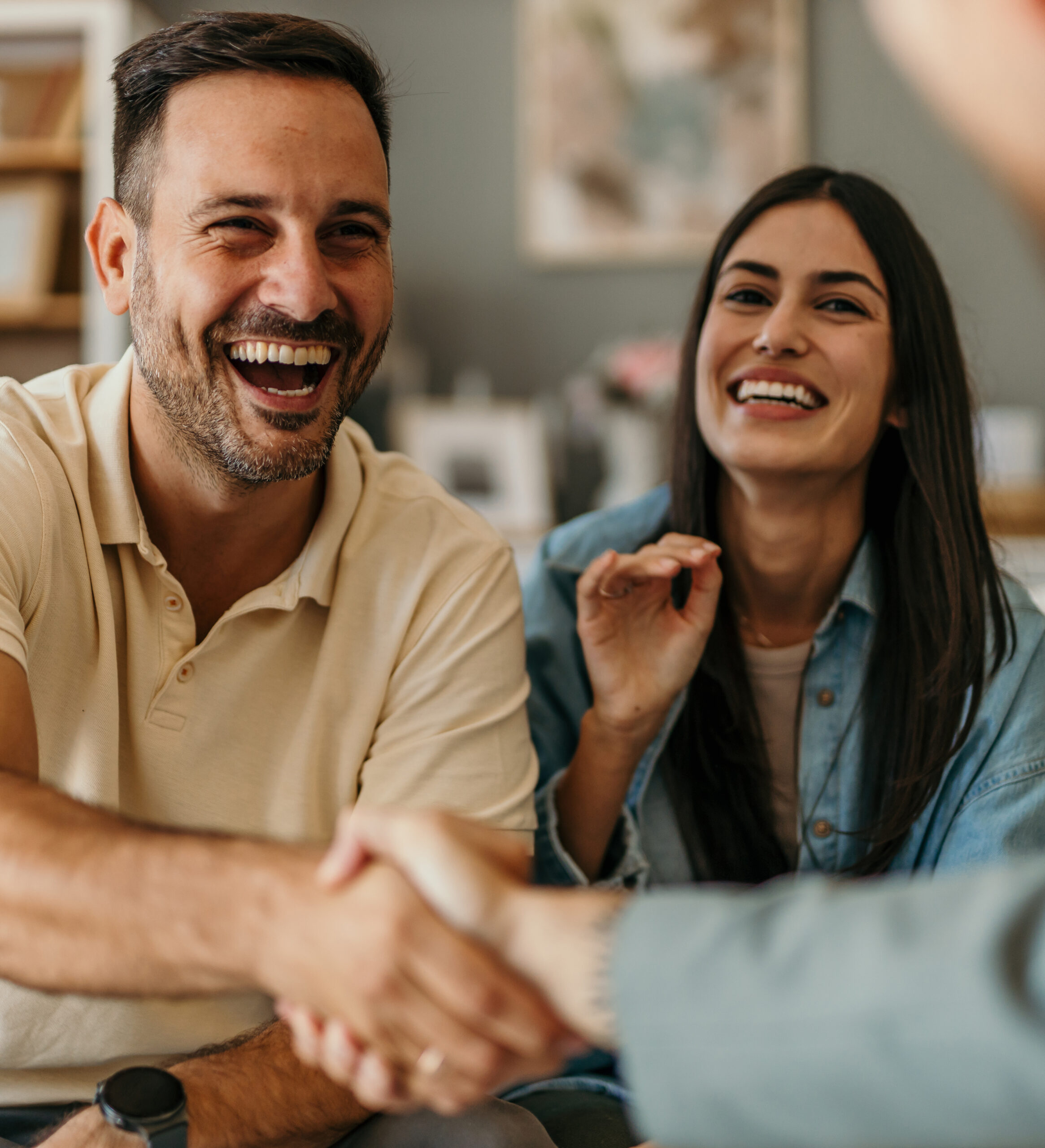 Young happy couple and an agent closing a deal