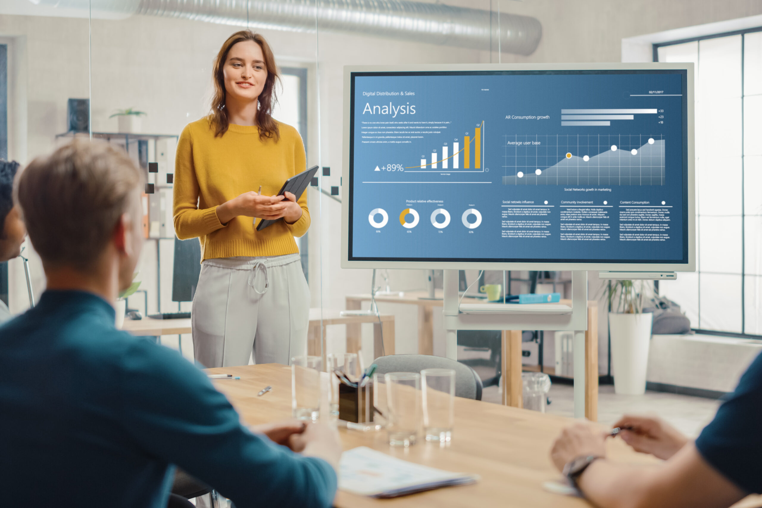 Woman presenting financial numbers to a team