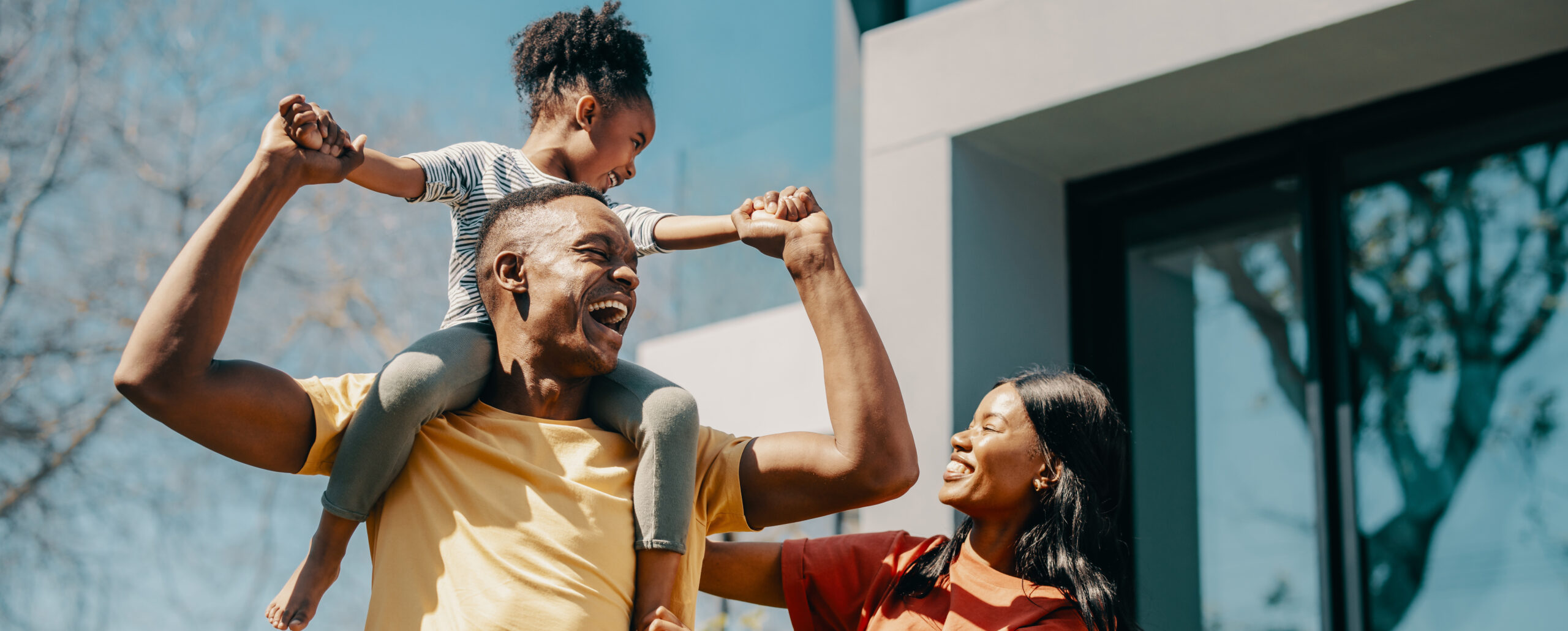 Happy family with the dad carrying his daughter on his shoulders