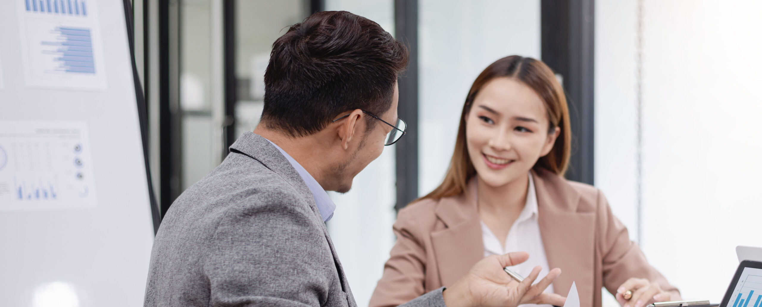 Two professionally dressed people talking about finances